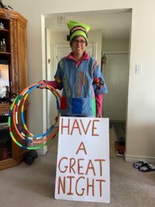 Woman-dressed-up-in-colourful-cloths-and-had-holding-several-colourful-hoola-hoops-and-sign-that-says-have-a-great-day